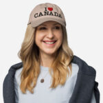 Front of I Love Canada stone classic dad hat on female model showing words 'I Love Canada' embroidered black with red heart for the word 'love'.