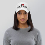 Front of I Love Canada white flat bill cap on female model showing words 'I Love Canada' embroidered black with red heart for the word 'love'.