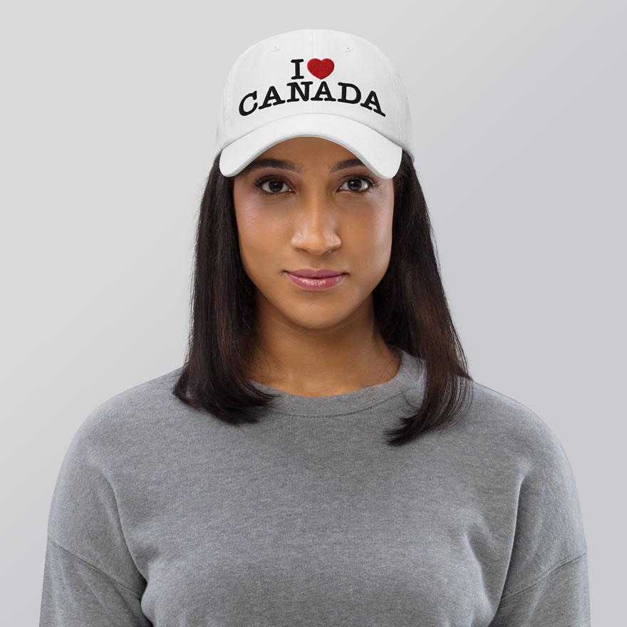 Front of I Love Canada white flat bill cap on female model showing words 'I Love Canada' embroidered black with red heart for the word 'love'.
