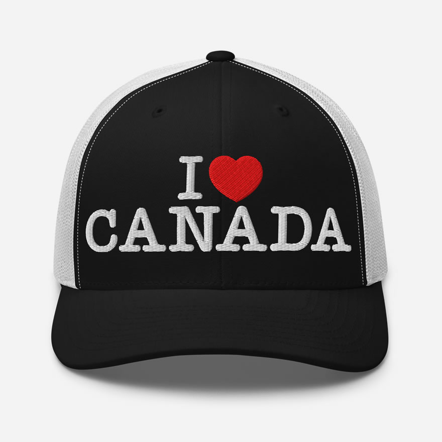 Words 'I Love Canada' embroidered white on front of a black and white retro trucker hat with a red heart in place of the word 'love'.