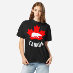Front of Canada Polar Bear black unisex heavyweight t-shirt on girl with maple leaf & Polar Bear print. Canada written below.