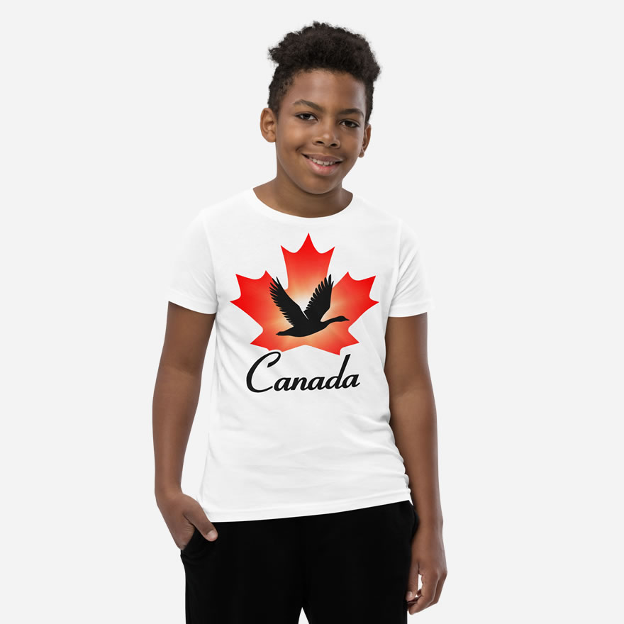Front of Canada Goose white unisex youth staple t-shirt on boy showing maple leaf & goose print. Canada written below.