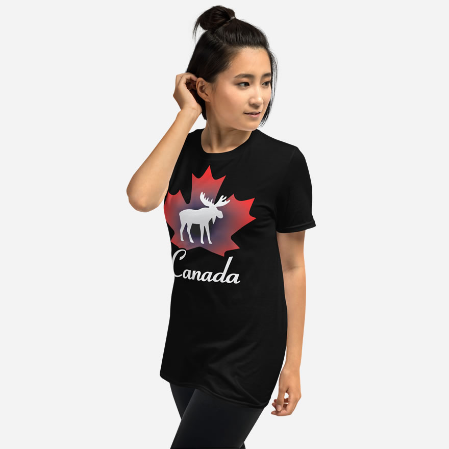 Front of Canada Moose black unisex softstyle t-shirt on female model showing maple leaf & moose print with Canada written below.