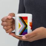 Canada Two-Spirit Intersex-Inclusive Progress Pride Flag white 11oz mug. Handle on left held by model. Flag has Intersex-Inclusive Progress Pride colours for left bar.