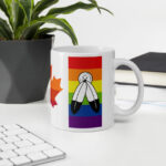 Canada Two-Spirit Intersex-Inclusive Progress Pride Flag white 11oz mug. Handle on right on office desk. Flag has Two-Spirit Pride stripes and feathers for right bar.