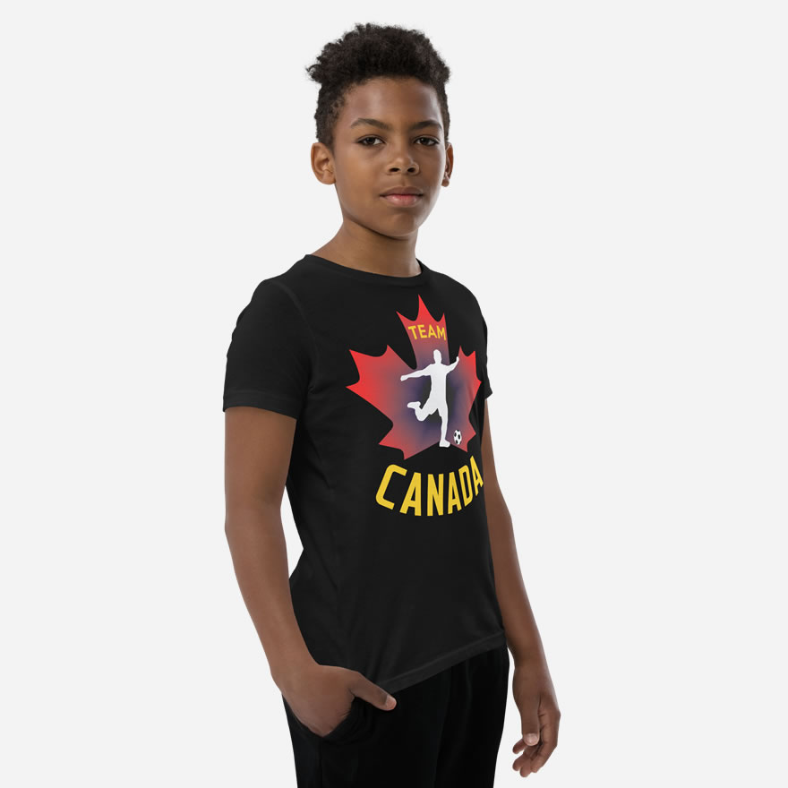 Front of Boy's Soccer black youth staple t-shirt on boy. Player kicking ball silhouette on red maple leaf. Says Team Canada.