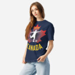 Front of Men's Soccer true navy heavyweight tee on woman. Player kicking ball silhouette on red maple leaf. Says Team Canada.