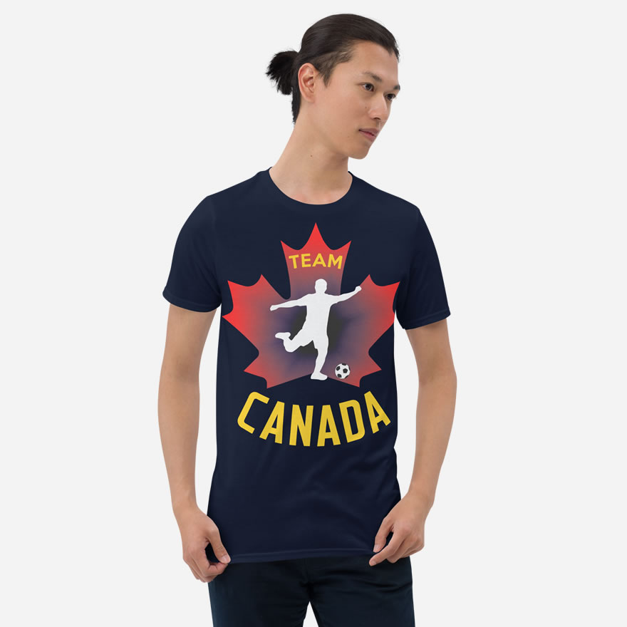 Front of Men's Soccer navy unisex t-shirt on man. Player kicking ball silhouette on maple leaf. Says Team Canada.