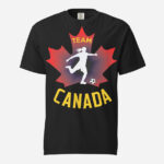 Front of Women's Soccer black unisex heavyweight t-shirt. Player kicking ball silhouette on red maple leaf. Says Team Canada.