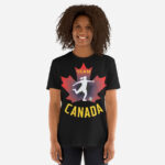Front of Women's Soccer black unisex t-shirt on woman. Player kicking ball silhouette on maple leaf. Tee says Team Canada.