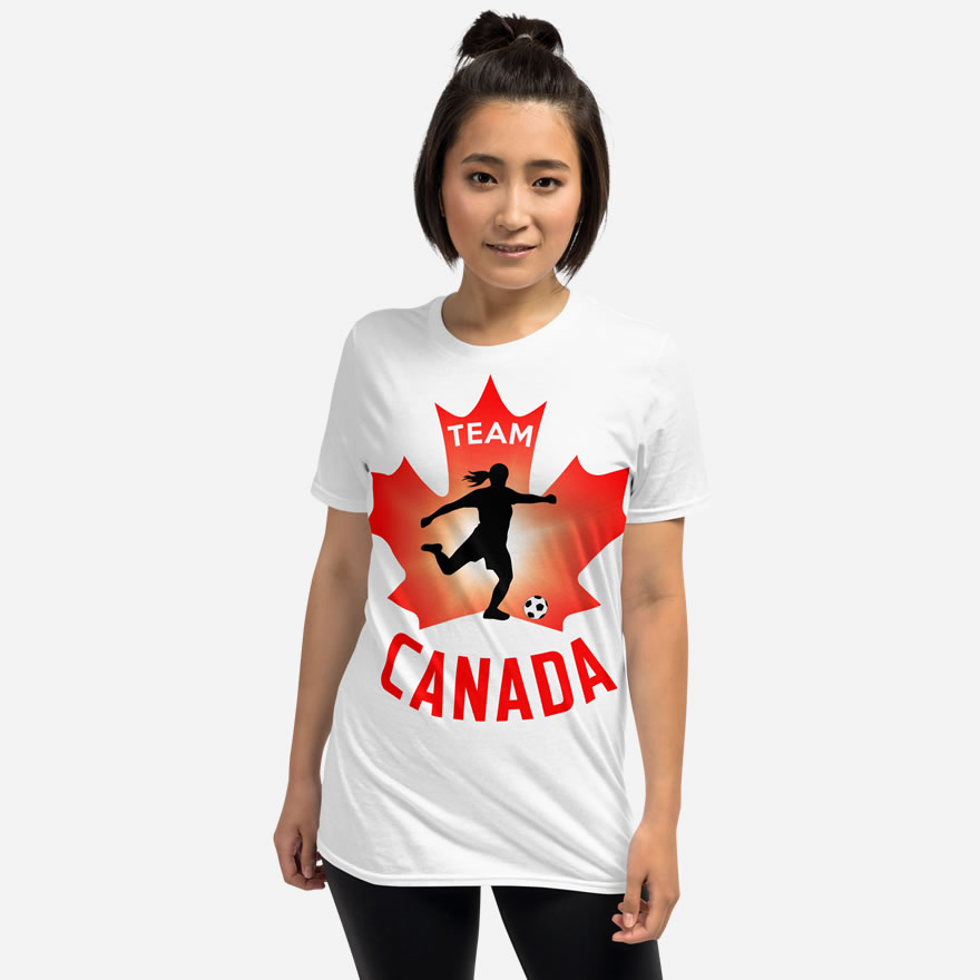 Front of Women's Soccer white unisex t-shirt on woman model. Player kicking ball figure on maple leaf. Tee says Team Canada.