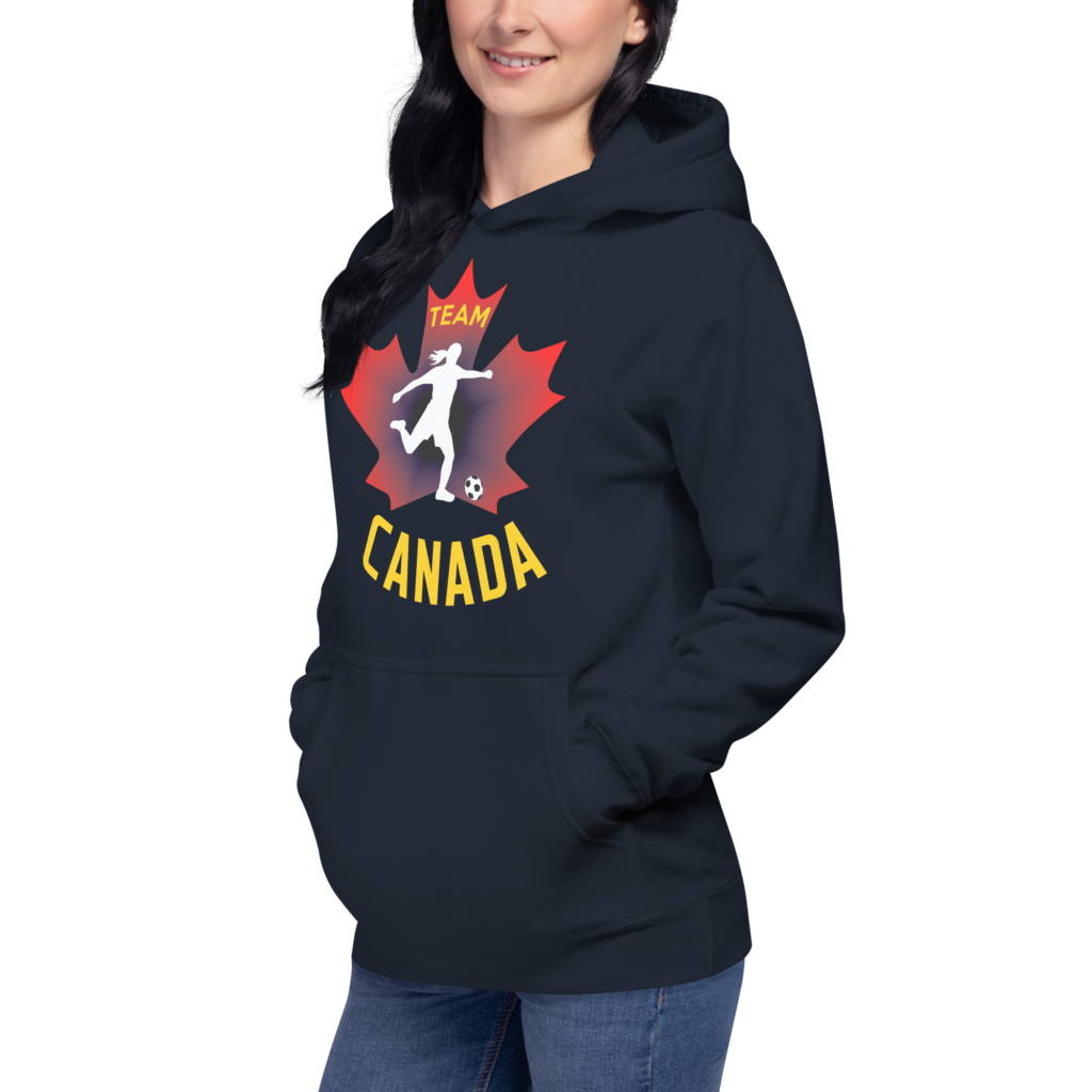 Front of Women's Soccer navy blazer premium hoodie on woman. Player kicking ball silhouette on maple leaf. Says Team Canada.