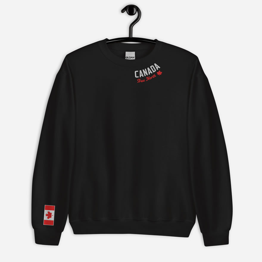 Front of black Canada True North sweatshirt embroidered in white, red with red maple leaf curved along neckline. Flag on right wrist.