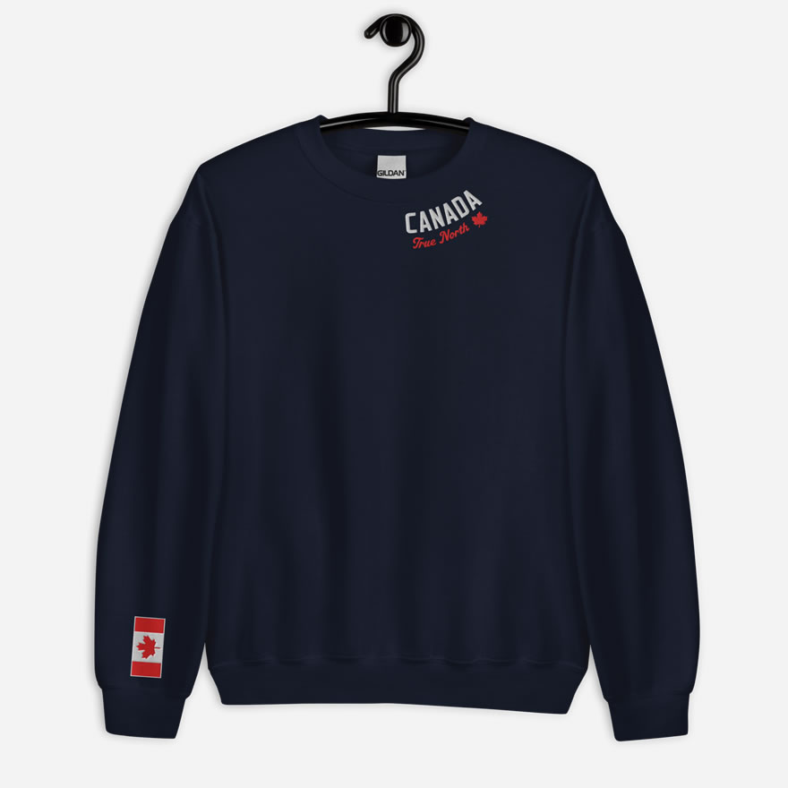 Front of navy Canada True North sweatshirt embroidered in white, red with red maple leaf curved along neckline. Flag on right wrist.
