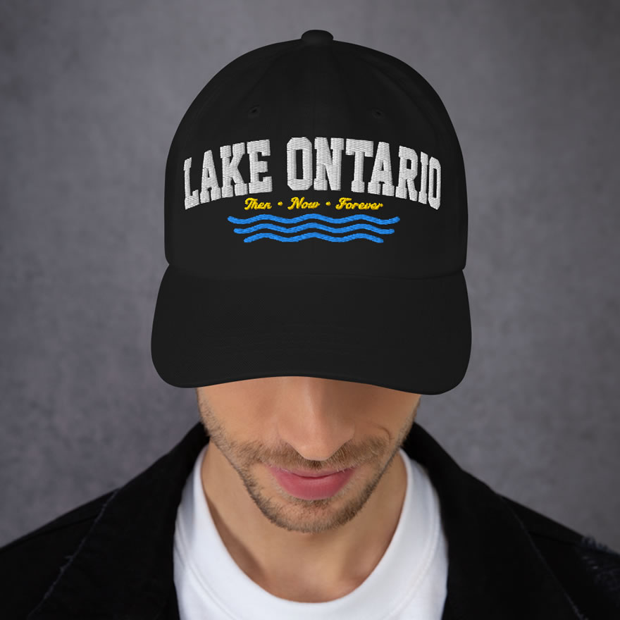 Front of Lake Ontario Canada black dad hat on model showing 'Lake Ontario' atop wavy lines embroidered white with red maple leaves.