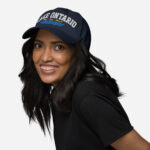 Front of Lake Ontario Canada navy dad hat on model showing 'Lake Ontario' atop wavy lines embroidered white with red maple leaves.