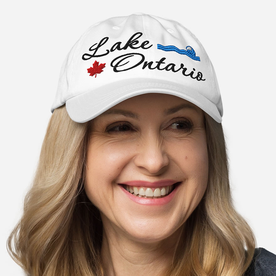 Front of Lake Ontario white classic dad hat on model showing 'Lake Ontario' embroidered black along with red maple leaf & blue wave.