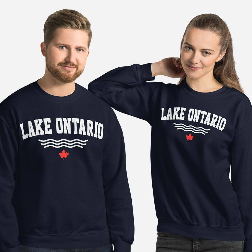 Front of Lake Ontario navy unisex crew neck sweatshirt on models with words Lake Ontario atop wavy lines (in white) above a red maple leaf.