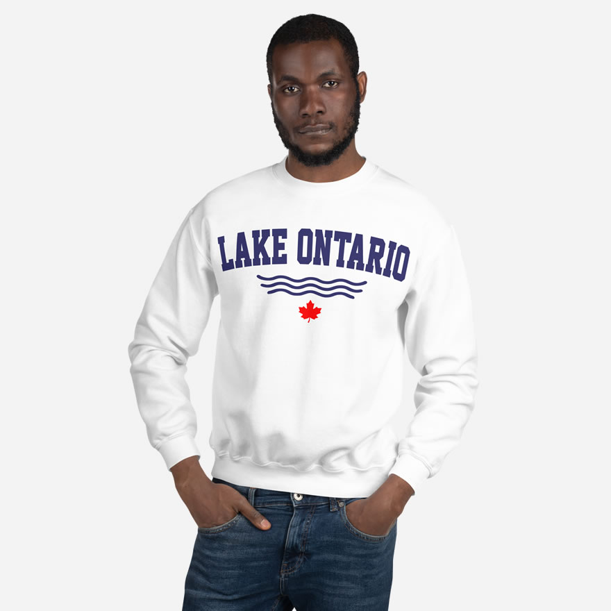 Front of Lake Ontario white unisex crew neck sweatshirt on model with words Lake Ontario atop wavy lines (in navy) above a red maple leaf.