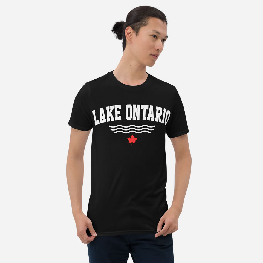 Front of Lake Ontario black t-shirt on model with words Lake Ontario atop wavy lines (in white) above a red maple leaf.