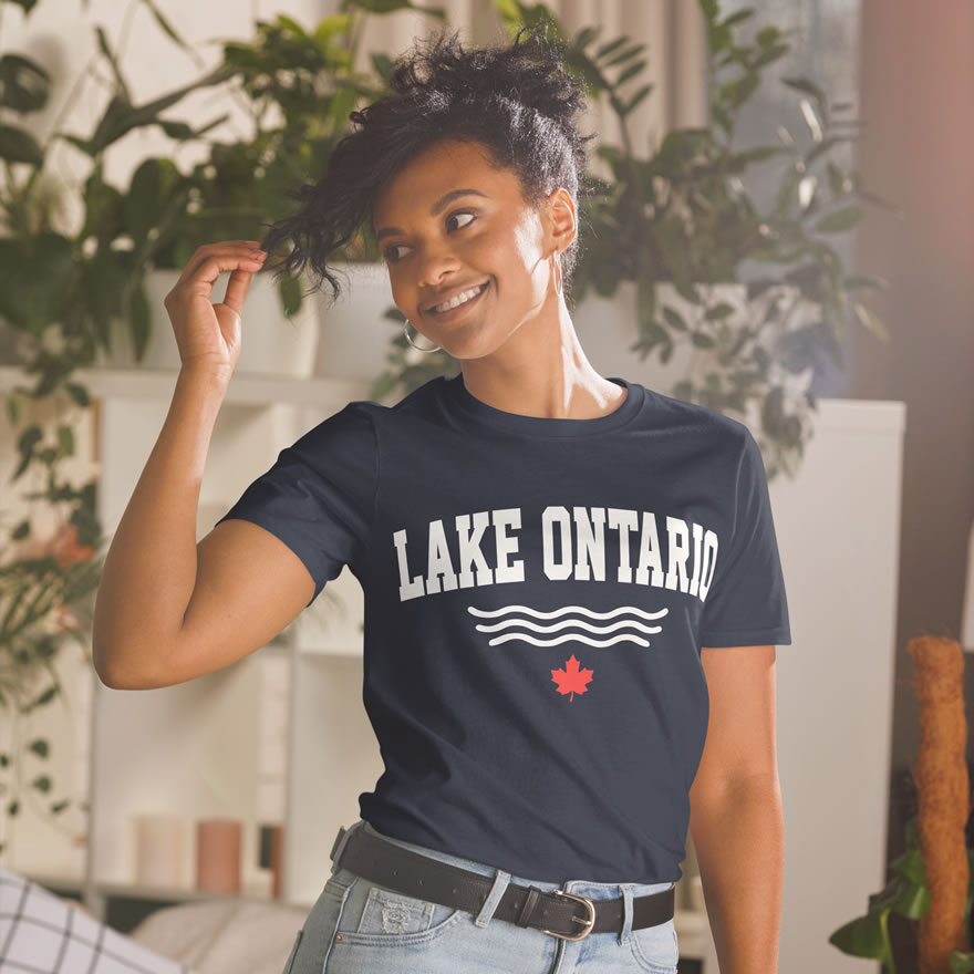 Front of Lake Ontario navy t-shirt on model with words Lake Ontario atop wavy lines (in white) above a red maple leaf.